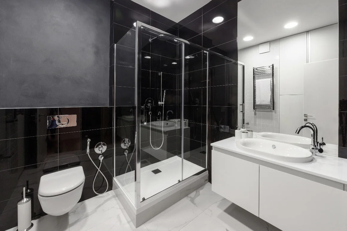 Modernes Badezimmer mit schwarzer Dusche und weissen Fliesen